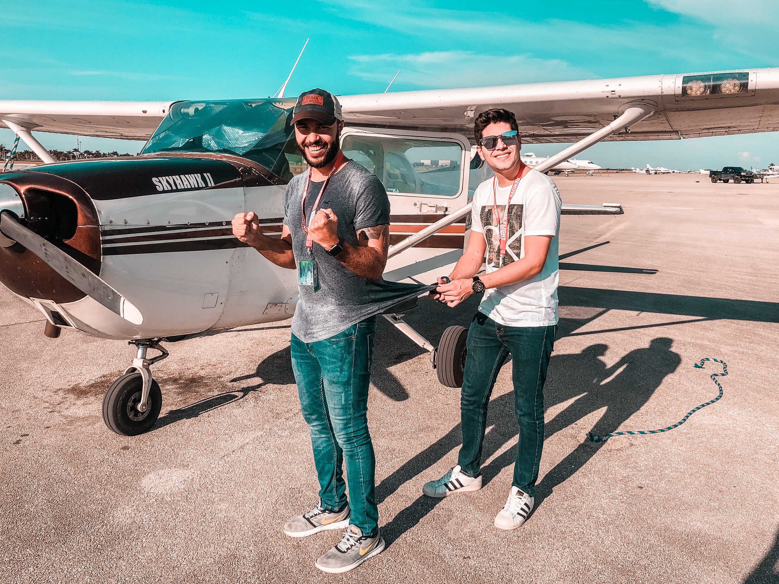 A photo of a flight instructor doing a celebratory cutting of the shirt after a student's first solo