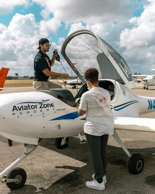 Young man standing outside of a Diamond Aircraft.